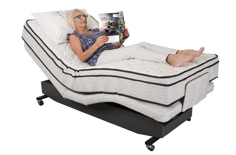 A woman reading a magazine on a therapy bed with the head raised